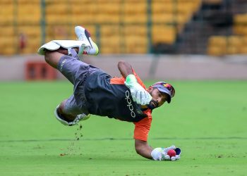 Dinesh Karthik dives for a catch during a practice session ahead of their maiden cricket Test match against Afghanistan, in Bangalore Monday