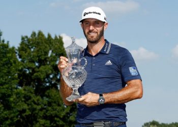 Dustin Johnson poses with his winners’ trophy at Memphis, Sunday