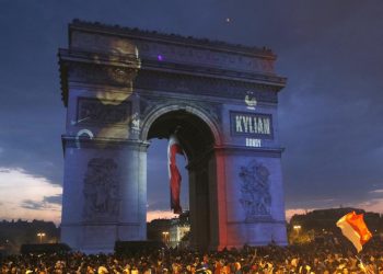 Kylian Mbappe's name is projected onto the Arc de Triomphe in Paris as fans invade the Champs-Elysees Avenue after France’s World Cup triumph, Sunday