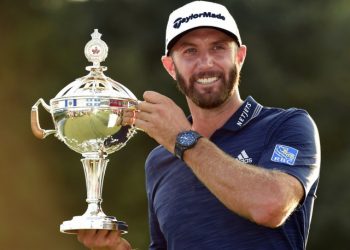 Dustin Johnson poses with the winner’s trophy in Toronto, Sunday