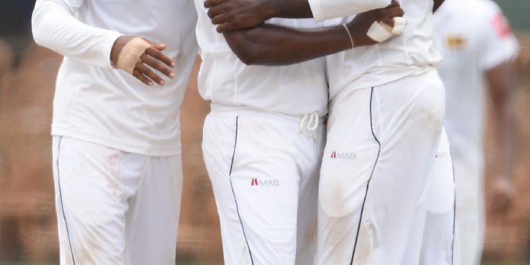 Rangana Herath celebrates with teammates after dismissing a South African batsman in Colombo, Monday