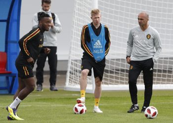 Belgium coach Roberto Martinez  R) speaks with Kevin De Bruyne (2nd L) as Michy Batshuayi shoots the ball during their training session, Wednesday