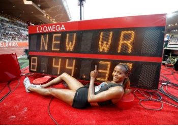 Caption
Kenya’s Beatrice Chepkoech poses besides the scoreboard which flashes the new world record time in the 3,000m steeplechase