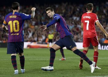 Lionel Messi joins Gerard Pique (C) while the latter wheels away for celebration after scoring Barcelona’s equaliser against Girona, Sunday 