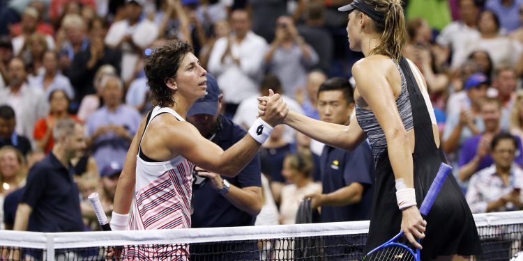 Maria Sharapova (in black) congratulates Carla Suarez Navarro after losing to the latter at the US Open, Monday 