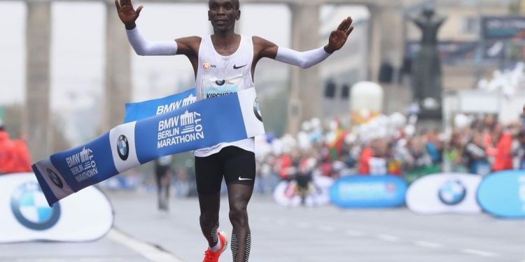 Kenyan Eliud Kipchoge raises his arms in delight after reaching the finish line to create a new world record at the Berlin Marathon, Sunday 