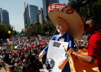 An anti-migrant demonstrator sporting a "Lucha Libre" wrestling mask attends a protest Sunday against the thousands of Central American migrants who are now camped out in Tijuana, Mexico. (Rodrigo Abd/Associated Press)