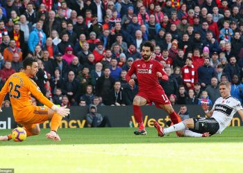 Mo Salah (in red) slots the ball under a hapless Fulham goalie Sergio Rico for Liverpool’s opening goal, Sunday