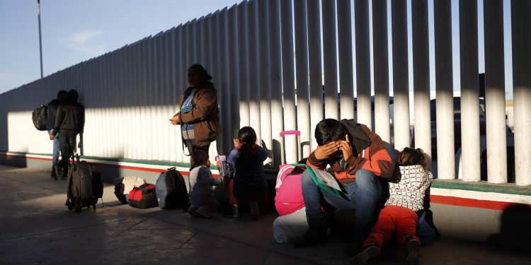 A migrant sits with his children as they wait to hear if their number is called to apply for asylum in the United States, at the border, Friday, Jan. 25, 2019, in Tijuana, Mexico. The Trump administration on Friday will start forcing some asylum seekers to wait in Mexico while their cases wind through U.S. courts, an official said, launching what could become one of the more significant changes to the immigration system in years. (AP)