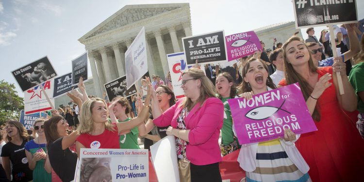 In this 2014 photo, demonstrators react to hearing the Supreme Court's decision on the Hobby Lobby birth control case outside the Supreme Court in Washington. A judge in California has blocked implementation of a Trump administration policy that would let more employers decline to offer birth control coverage on religious or moral grounds.