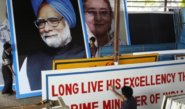 A painter prepares a welcome banner as portraits of former Prime Minister Manmohan Singh and Prime Minister Sheikh Hasina are moved in the background (Twitter)