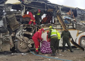 In this photo released by the Bolivian Police of Oruro, firefighters and police help a victim of a crash of two buses on the outskirts of Challapata, Bolivia, Saturday, Jan. 19, 2019. The crash killed dozens of people and left several injured on a road in the Bolivian highlands, police said. (AP)