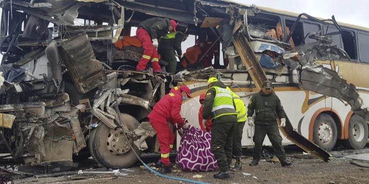 In this photo released by the Bolivian Police of Oruro, firefighters and police help a victim of a crash of two buses on the outskirts of Challapata, Bolivia, Saturday, Jan. 19, 2019. The crash killed dozens of people and left several injured on a road in the Bolivian highlands, police said. (AP)