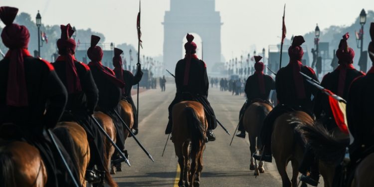 Members of the President's Bodyguard regiment ride towards the India Gate monument during rehearsals for the upcoming Republic Day