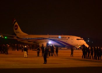 Bangladeshi security personnel stand guard near the hijacked Dubai-bound plane. Officials say the would-be hijacker was carrying a toy gun (AFP)