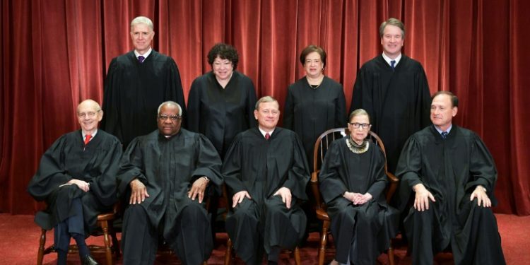 Justices of the US Supreme Court pose for their official photo on November 30, 2018: new conservative appointees Justice Neil Gorsuch and Brett Kavanaugh can be seen standing in the back row at the far left and right (AFP)