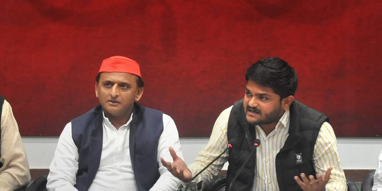 Akhilesh Yadav (L) listens as Hardik Patel talks to reporters in Lucknow, Thursday