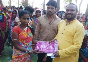 BJD MLA Manohar Randhari(R) distributing saris to people