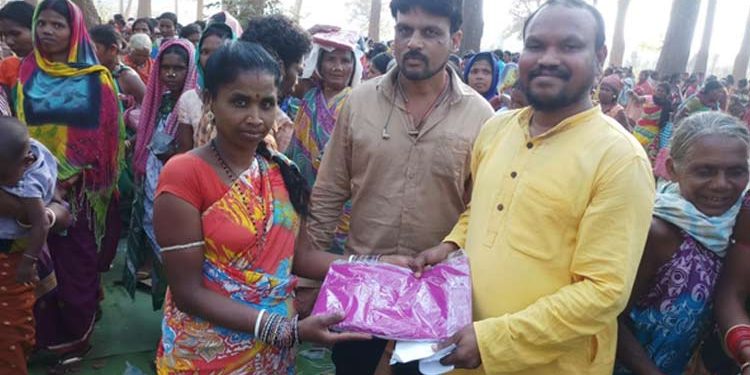 BJD MLA Manohar Randhari(R) distributing saris to people