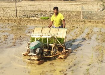 Prashant Kumar Biswal with a transplantation machine in his farmland