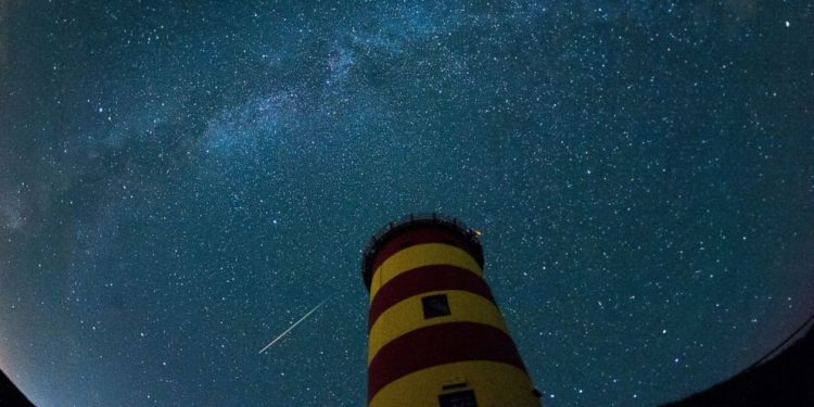 A falling star crosses the night sky behind a lighthouse is pictured during the peak in activity of the annual Perseids meteor shower Aug. 13, 2015 in Pilsum, Germany. (AFP) [Representational Image]