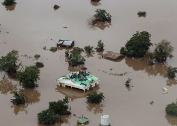 Groups of people stuck on rooftops with floodwaters up to window level in Beira. (AFP)