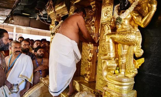 A priest closes doors at the Ayyappa shrine at the Sabarimala temple in Kerala after performing “purification” rituals following the entry of two women yesterday. (AFP)