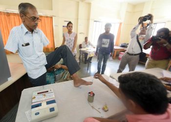 AHMEDABAD, APR 23 (UNI) Polling officials marking a deferently abled voter with indelible ink prior to cast his vote at a polling centre during the 3rd phase of General Election, in Ahmadabad on Tuesday.UNI PHOTO-56U