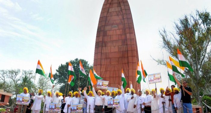 Activists of the All India Anti Terrorist Front (AIATF) hold Indian national flags as they shout patriotic slogans while paying tribute to the martyrs ahead of 100th anniversary of the JallianwalaBagh massacre, at its memorial in Amritsar on Thursday (PTI photo)