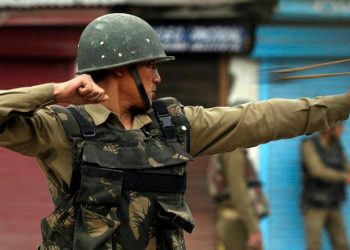 An Indian policeman uses a sling shot to tackle unruly protesters at Kashmiri protesters during an anti-election protest in Srinagar. (Reuters)