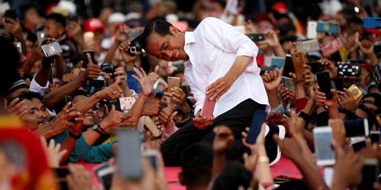 FILE PHOTO: Indonesia's presidential candidate for the upcoming general election Joko Widodo takes pictures with his supporters during his first campaign rally at a stadium in Serang, Banten province, Indonesia, March 24, 2019. REUTERS/Willy Kurniawan/File Photo