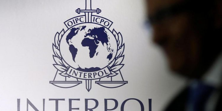 A man passes an Interpol logo during the handing over ceremony of the new premises for Interpol's Global Complex for Innovation, a research and development facility, in Singapore September 30, 2014. REUTERS/Edgar Su/File Photo