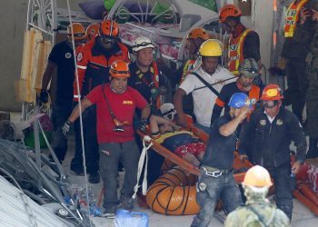 Rescuers carry an earthquake survivor after being pulled out from the rubble of a commercial building following Monday's 6.1 magnitude earthquake in Porac township, Pampanga province, north of Manila, Philippines, Tuesday, April 23, 2019. The strong earthquake struck the northern Philippines Monday trapping some people in a collapsed building, damaged an airport terminal and knocked out power in at least one province, officials said. (AP Photo/Bullit Marquez)