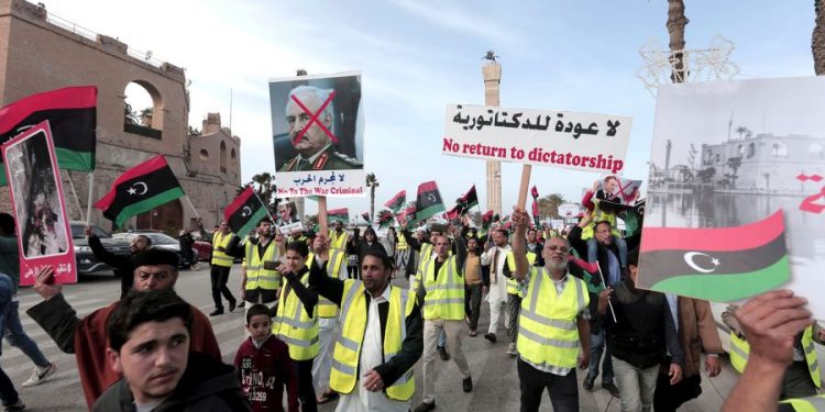 Protesters wear yellow vests at a protest in Tripoli, Libya, Friday, April 19, 2019, as they wave national flags and chant slogans against Libya's Field Marshal Khalifa Hifter, who is leading an offensive to take over the capital. (HAZEM AHMED/AP)