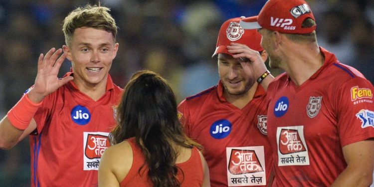 Sam Curran (L) and other KXIP players celebrate with franchise owner Preity Zinta (back to the camera) after beating Delhi Capitals, Monday