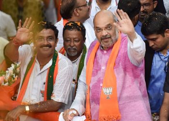 Kolkata: BJP National President Amit Shah waves at supporters during an election roadshow in support of north Kolkata's party candidate Rahul Sinha for the last phase of Lok Sabha polls, in Kolkata, Tuesday, May 14, 2019. Also seen is party leader Babul Supriyo. (PTI Photo/Ashok Bhaumik) (PTI5_14_2019_000126B)