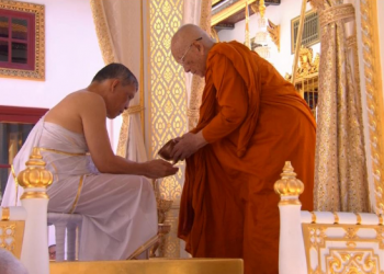 Thailand's King Maha Vajiralongkorn, donning white robes, undergoes a purification ritual during a ceremony before being officially crowned in Bangkok, Thailand, Saturday