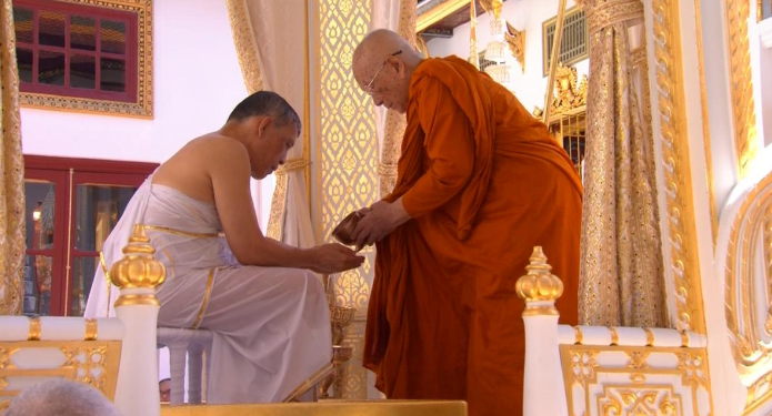 Thailand's King Maha Vajiralongkorn, donning white robes, undergoes a purification ritual during a ceremony before being officially crowned in Bangkok, Thailand, Saturday