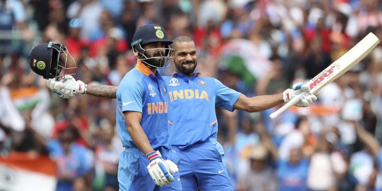 Shikhar Dhawan celebrates after scoring a century against Australia as skipper Virat Kohli watches