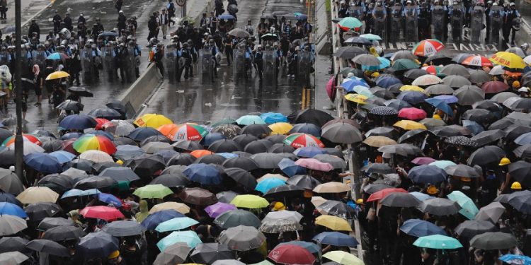 Protesters holding umbrellas face off against police officers  in Hong Kong Monday, July 1, 2019.