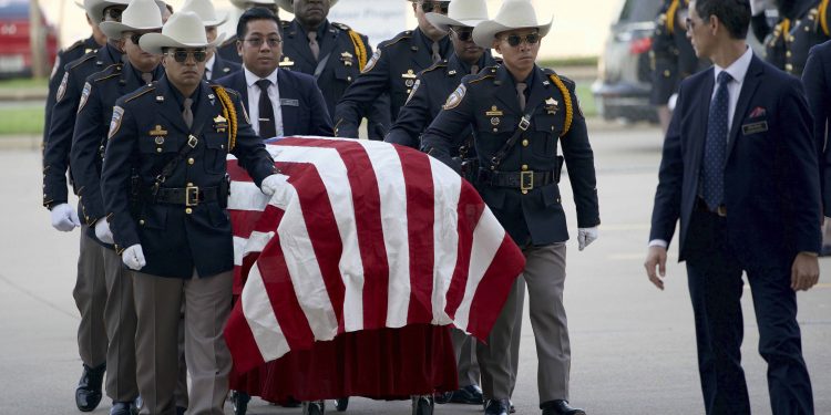 The coffin of slain cop Sandeep Singh Dhaliwal draped in an American flag being carried for funeral