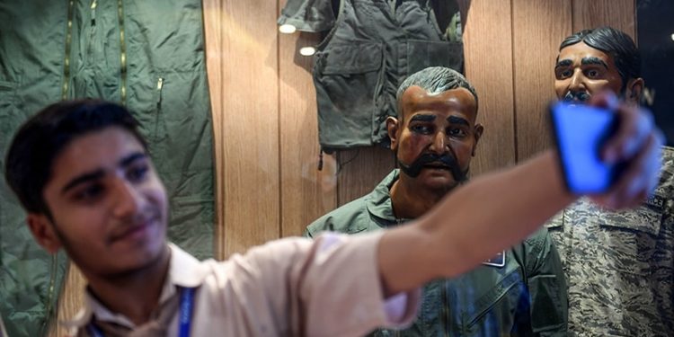 A student takes a selfie in front of the statue of Indian pilot Wing Commander Abhinandan Varthaman (2R) whose plane was shot down over Kashmir earlier this year, put on display at Pakistan Air Force Museum in Karachi on November 12, 2019. (Photo by Asif HASSAN / AFP)