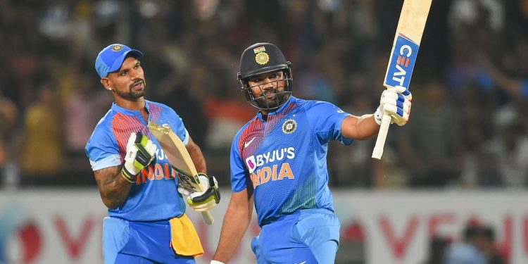 India's stand-in captain Rohit Sharma  raises his bat after reaching his half century against Bangladesh as fellow opener Shikhar Dhawan watches