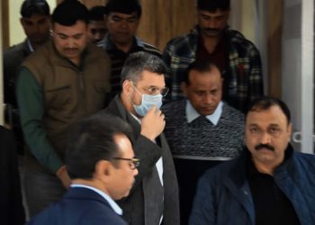 Bookie Sanjeev Chawla (face covered) being escorted out of the Delhi Airport by Crime Branch officers