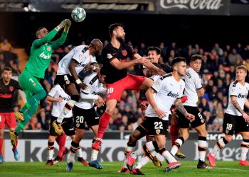 Valencia's Spanish goalkeeper Jaume Domenech (L) jumps for the ball during the Spanish league football match between Valencia CF and Club Atletico de Madrid at the Mestalla stadium in Valencia on February 14, 2020. (Photo by JOSE JORDAN / AFP)