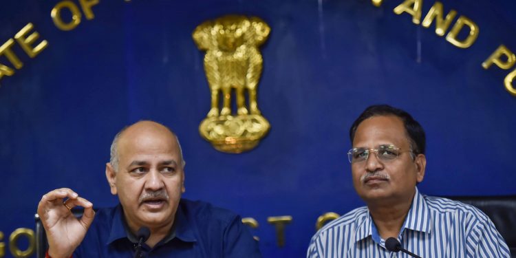 Delhi Deputy Chief Minister Manish Sisodia addresses a press conference as Health Minister Satyendra Jain (R) looks on