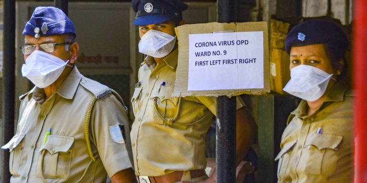 Security personnel wear protective masks as they wait outside the isolation ward of a Mumbai hospital