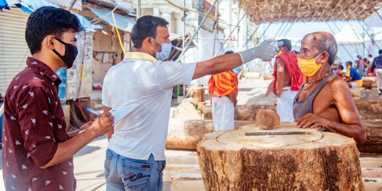 A Maharana servitor undergoes thermal screening in Puri