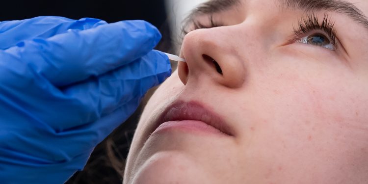 23 March 2020, Bavaria, Munich: Medical personnel demonstrate the collection of a nasal swab in a new test station in front of the Tropical Institute for people suspected of having Covid-19. Only medical personnel and specific professional groups such as the police or fire brigade will be tested at the new test station. Photo: Sven Hoppe/dpa (Photo by Sven Hoppe/picture alliance via Getty Images)