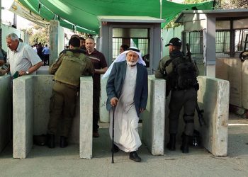 Israeli security forces keep watch as Palestinians cross a checkpoint to reach the city of Jerusalem to attend the last Friday prayers of Ramazan in the al-Aqsa mosque compound, April 29 in Bethlehem in the occupied West Bank. — AFP